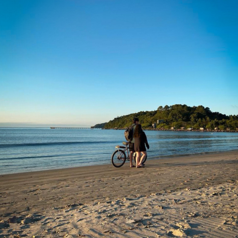 casal caminha junto pela praia